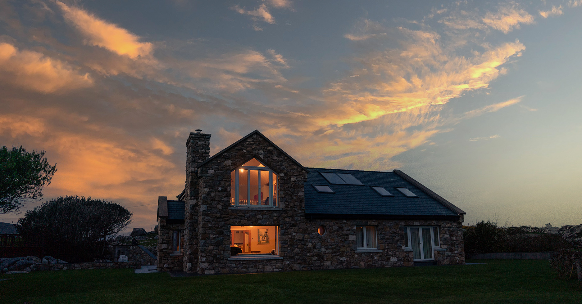 A photo of Whale harbour cottage in Connemara at sunset showcasing this rental cottage by the beach in Roundstone